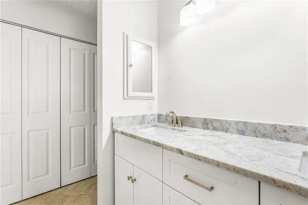 a bathroom with a granite countertop sink and a mirror