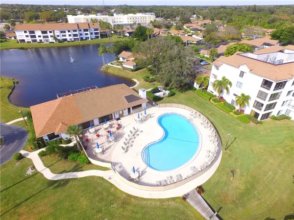 a view of a house with pool and chairs