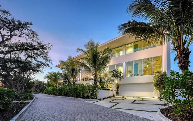 a view of a house with a yard and palm trees