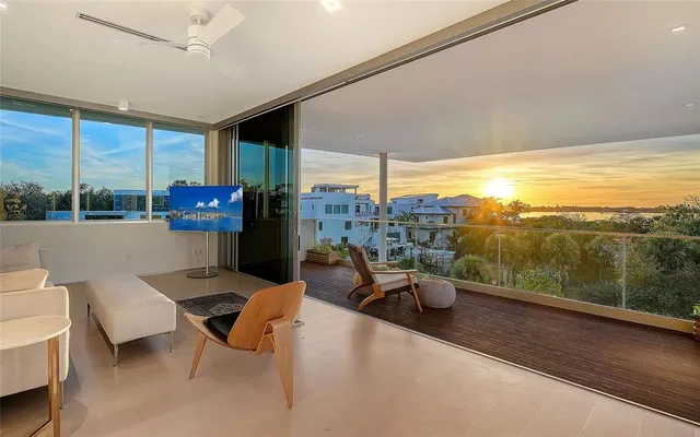 a living room with patio furniture and a flat screen tv