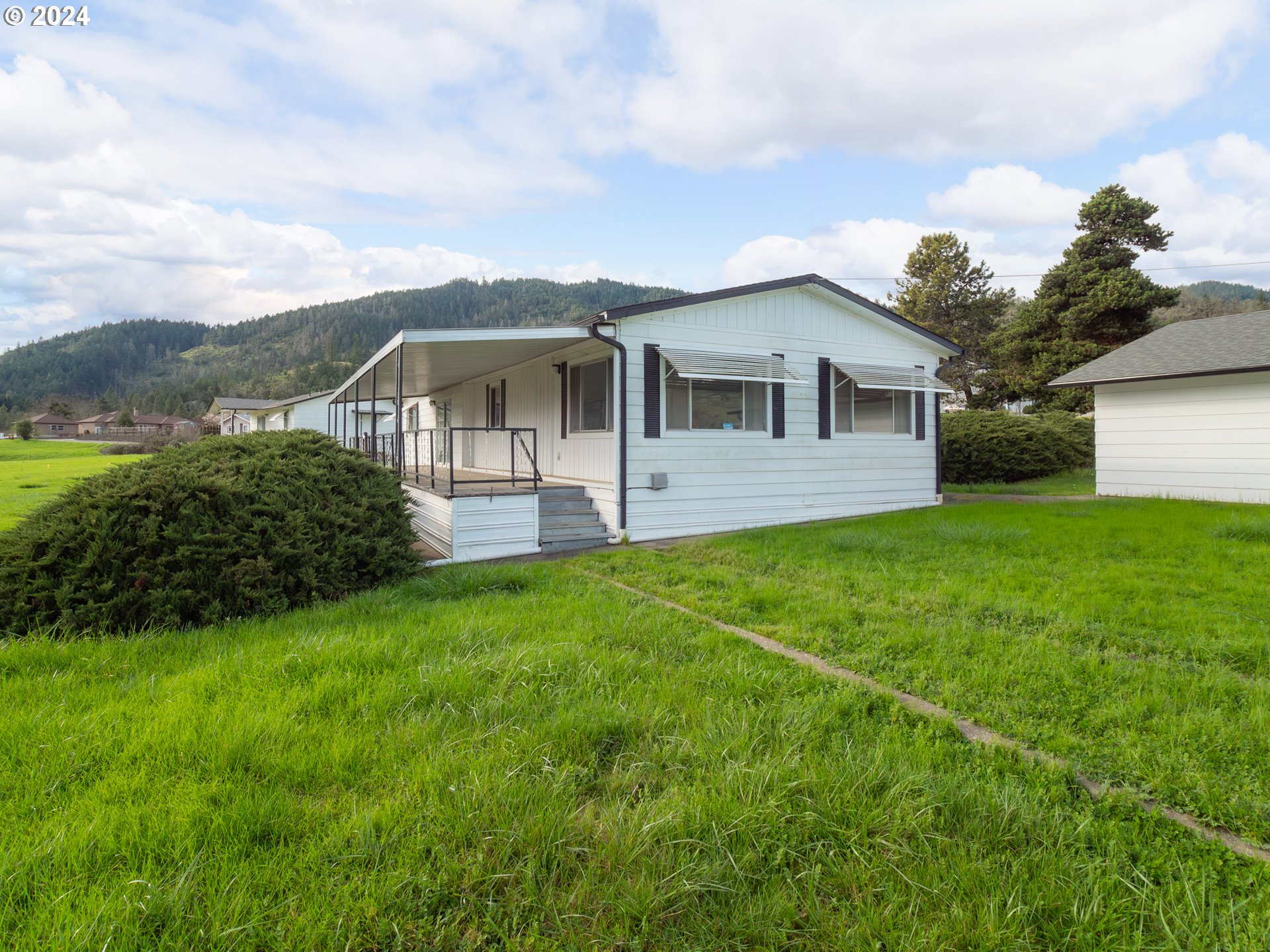 150 Spring Brook Road Myrtle Creek, OR 97457 - Photo 2 of 42 a front view of a house with garden