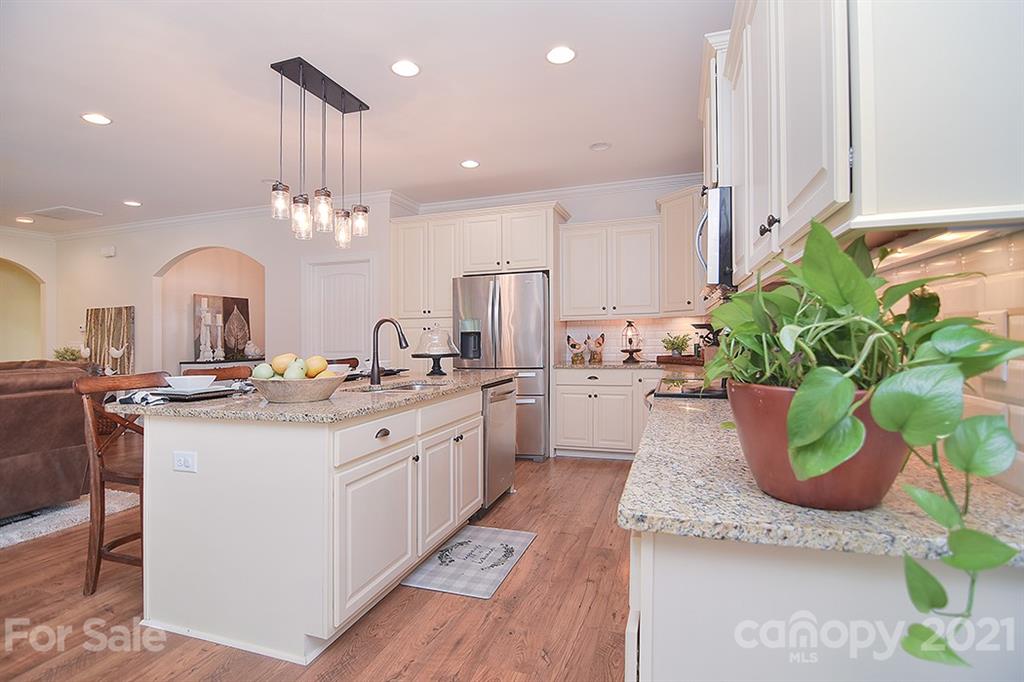 5813 Dudley Road Monroe, NC 28112 - Photo 12 of 44 a large white kitchen with a sink and a large mirror