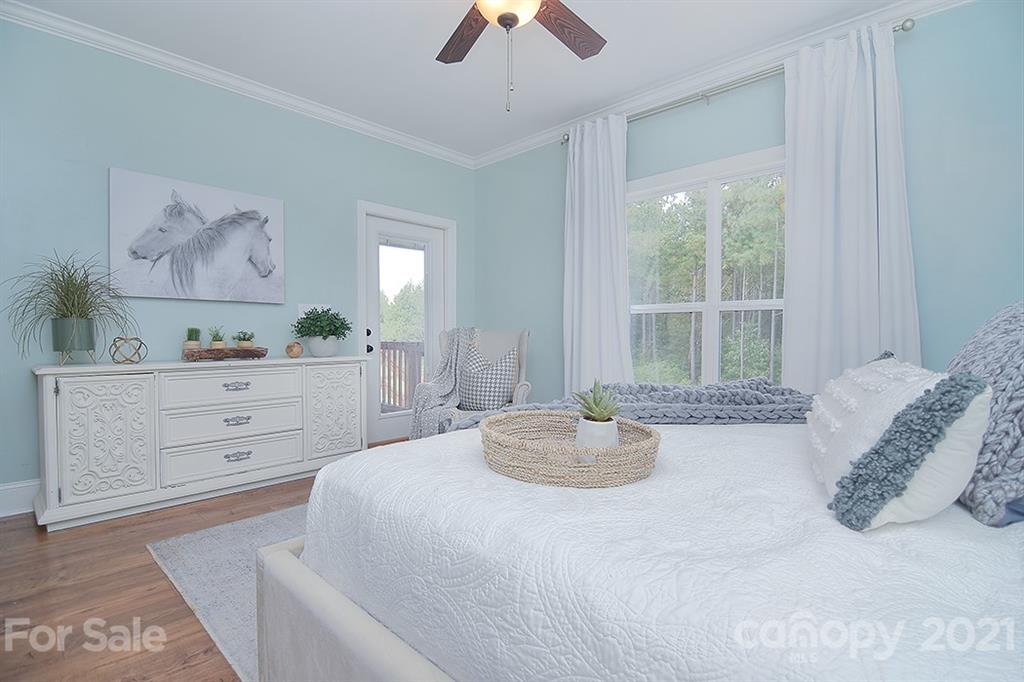 5813 Dudley Road Monroe, NC 28112 - Photo 22 of 44 a bedroom with a bed and a chandelier