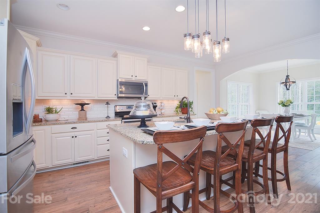 5813 Dudley Road Monroe, NC 28112 - Photo 10 of 44 a kitchen with a dining table chairs cabinets and stainless steel appliances