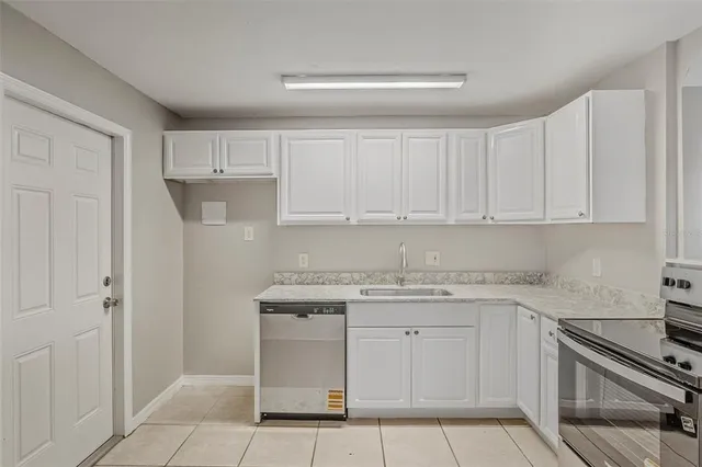 a kitchen with white cabinets stainless steel appliances and sink