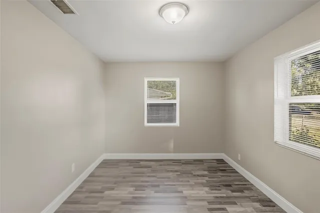 wooden floor in an empty room with a window