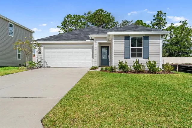 a front view of a house with a garden and plants
