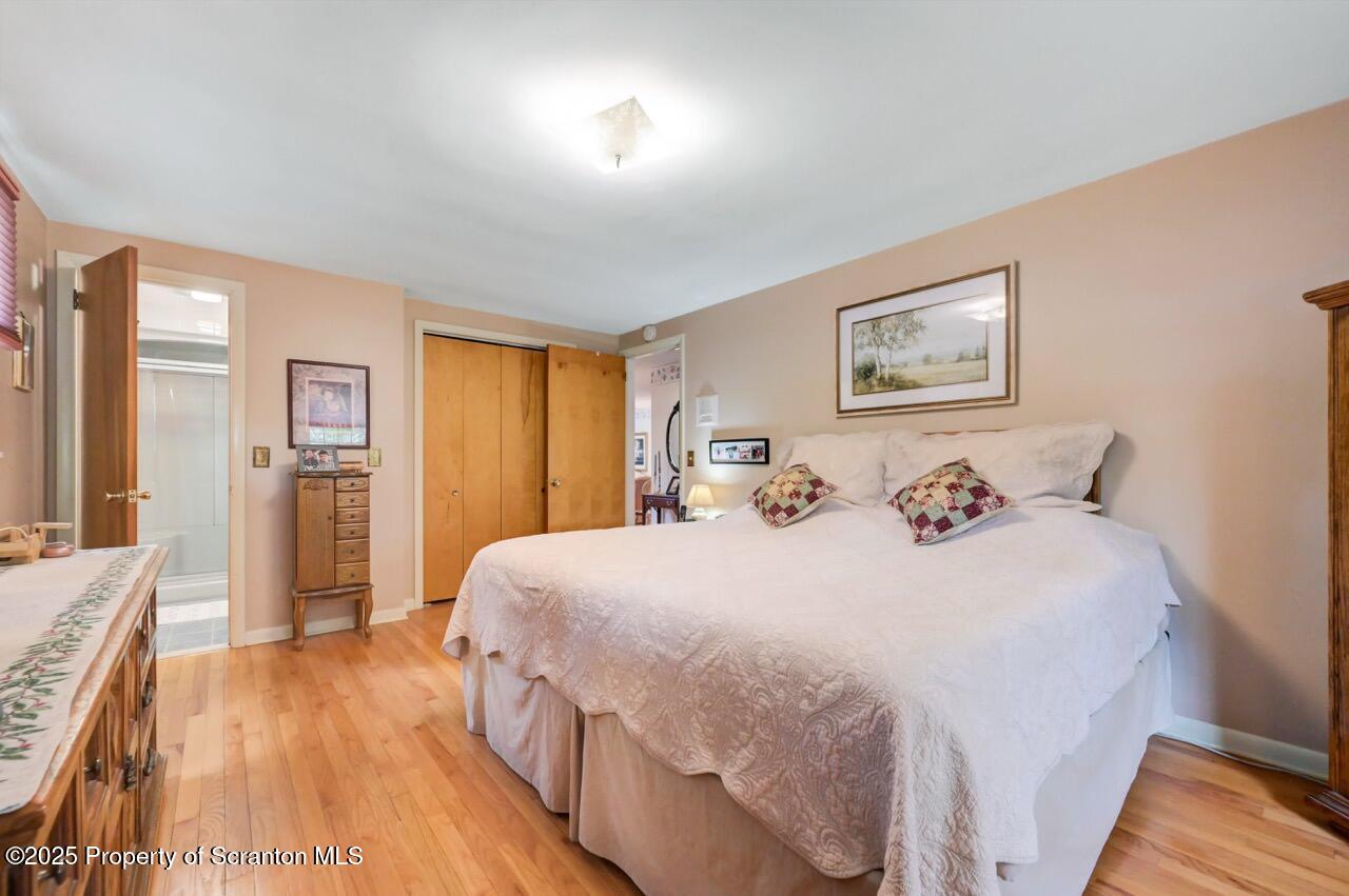 1020 Sleepy Hollow Road Clarks Summit, PA 18411 - Photo 30 of 62 a bedroom with a large bed and a chandelier