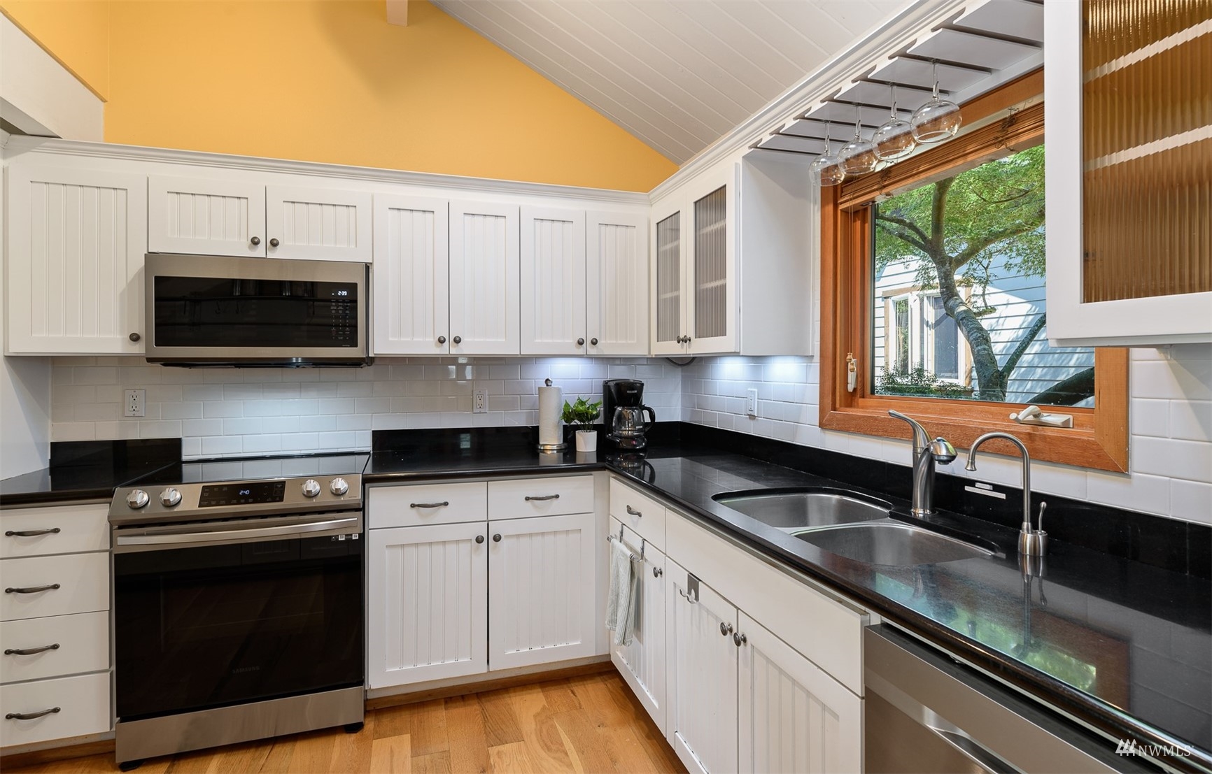 5166 Bayview Road Langley, WA 98260 - Photo 13 of 40 a kitchen with stainless steel appliances granite countertop a sink a stove and a microwave