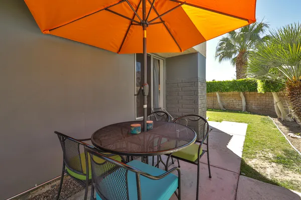a view of a backyard with table and chairs and potted plants