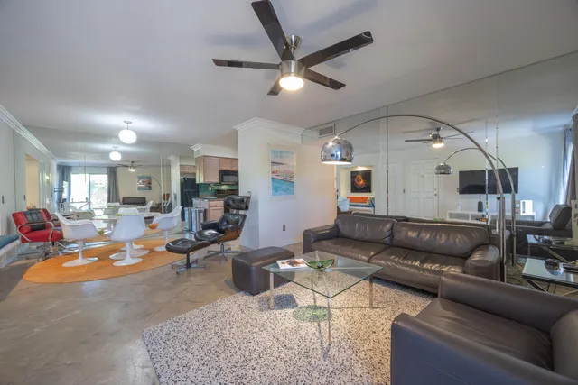 a living room with furniture kitchen view and a chandelier