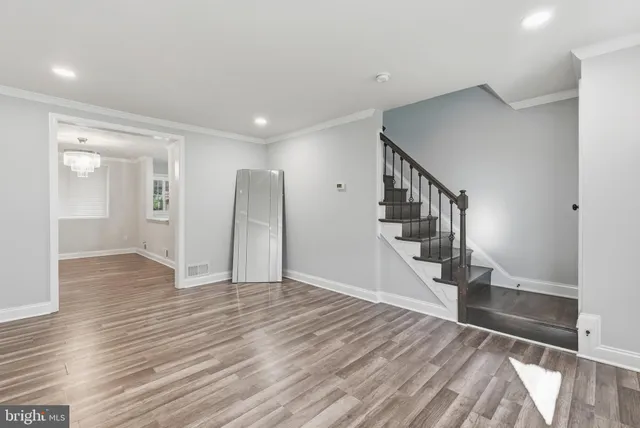 a view of a hallway with wooden floor and staircase