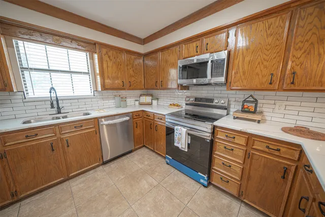 an empty room with chandelier fan and windows