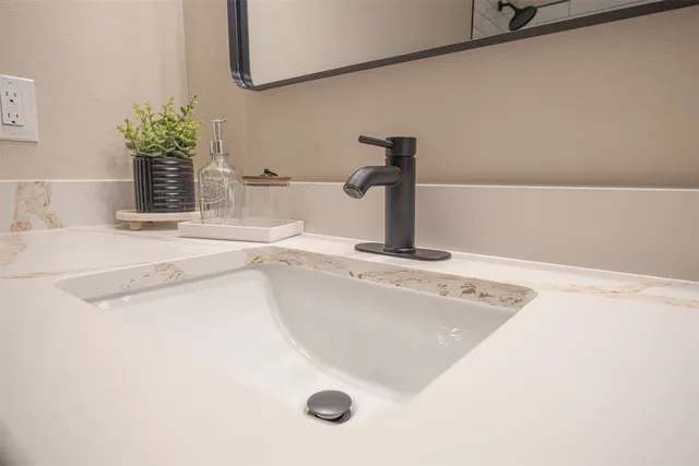 a front view of a house with a yard and a large tree