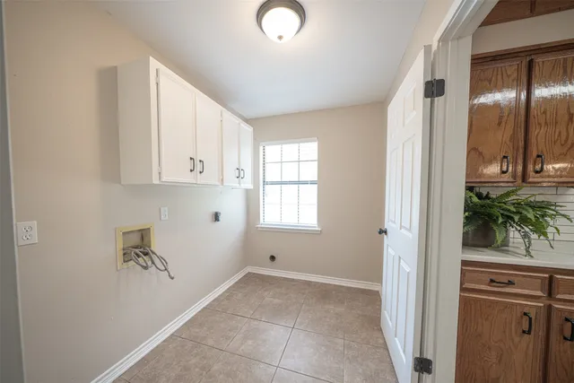 a kitchen with a sink a stove cabinets and a potted plant