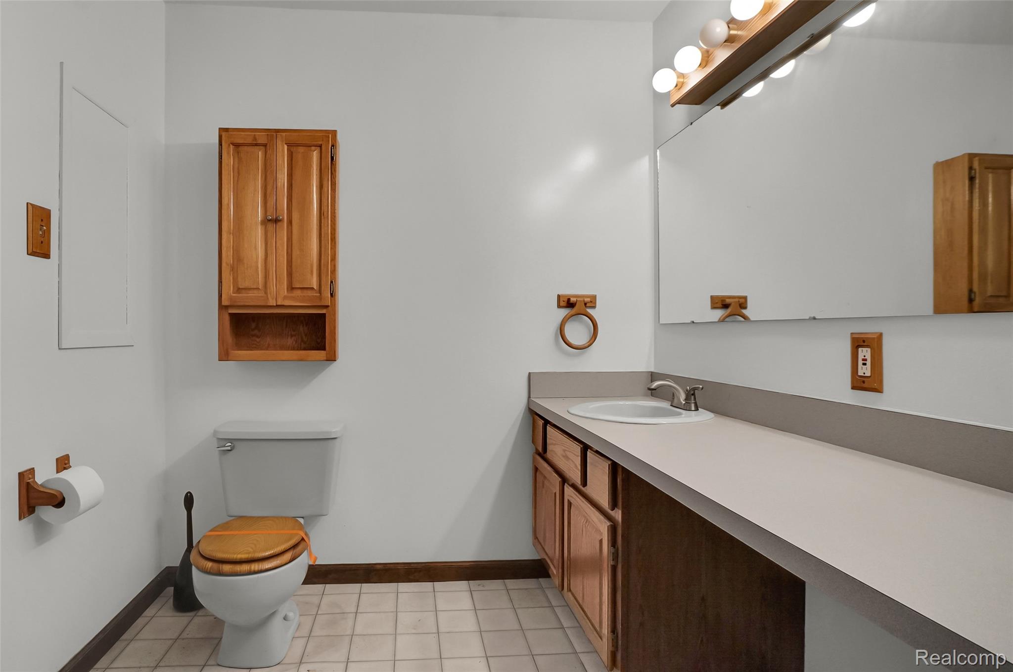 1431 East Commerce Road Commerce Township, MI 48382 - Photo 18 of 27 Half bath featuring vanity and light tile patterned floors