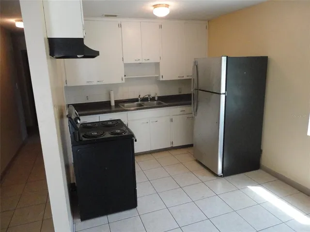 a kitchen with stainless steel appliances granite countertop a refrigerator and a stove