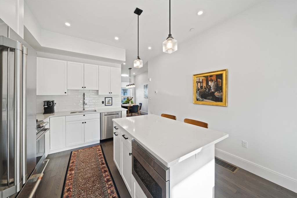 17-31 Charles Park Road, Unit 196 Boston, MA 02132 - Photo 5 of 25 a kitchen that has a lot of cabinets in it and wooden floors