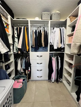 a view of walk in closet with clothes and shoes