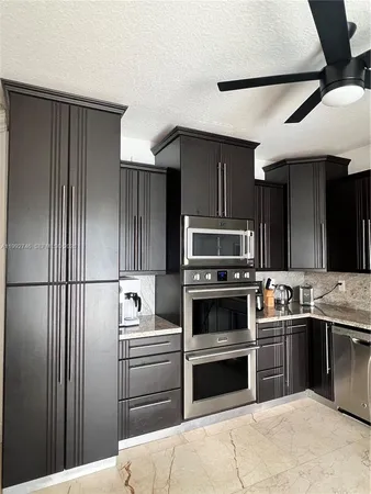 a kitchen with a refrigerator sink and wooden cabinets