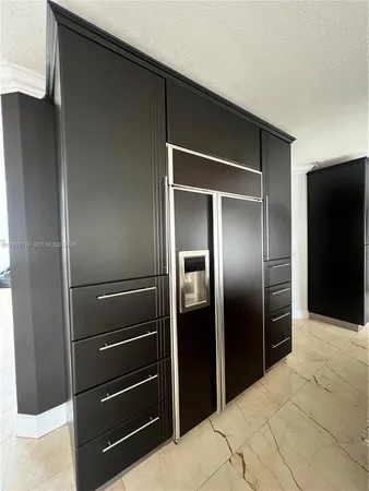 a kitchen with refrigerator and wooden floor