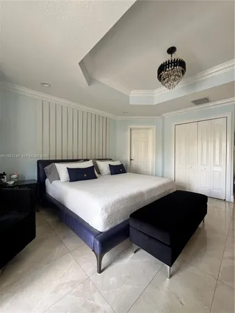 a spacious bedroom with a bed and a chandelier