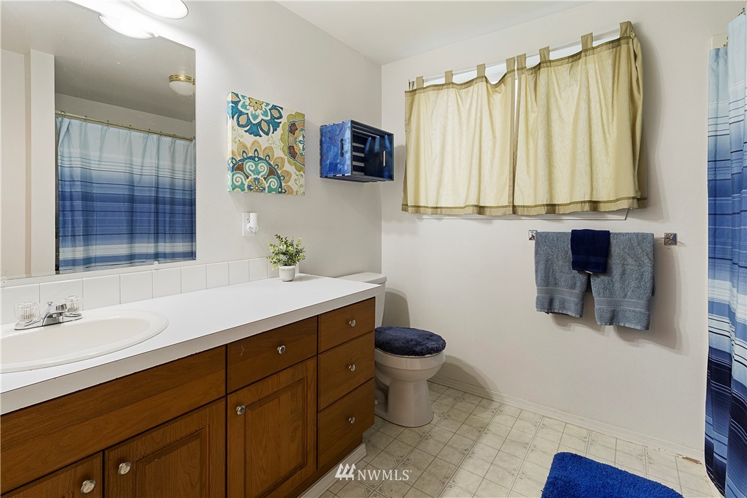 26410 218th Avenue Southeast Maple Valley, WA 98038 - Photo 19 of 28 a bathroom with a sink toilet a mirror and window