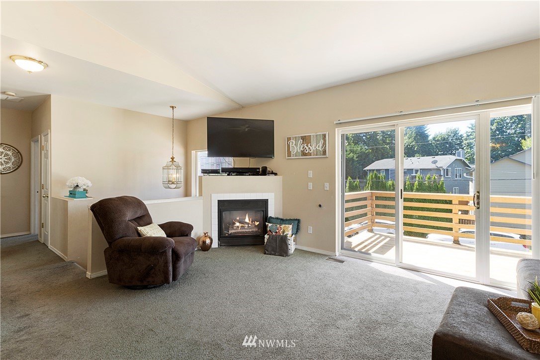 26410 218th Avenue Southeast Maple Valley, WA 98038 - Photo 7 of 28 a living room with furniture a fireplace and a flat screen tv