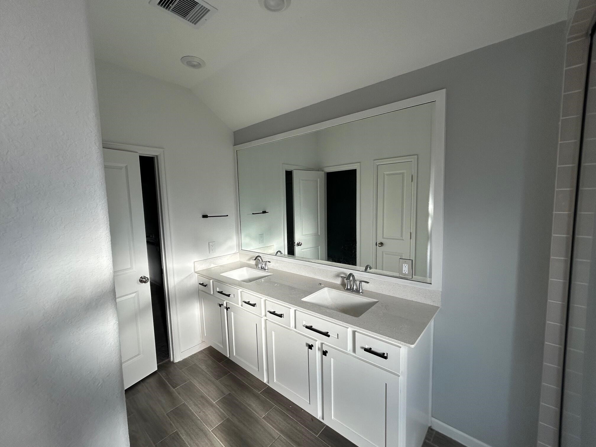 975 Lars Trek Trail Conroe, TX 77304 - Photo 12 of 36 a bathroom with a sink a vanity and a mirror