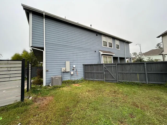 a view of a house with a yard and wooden fence