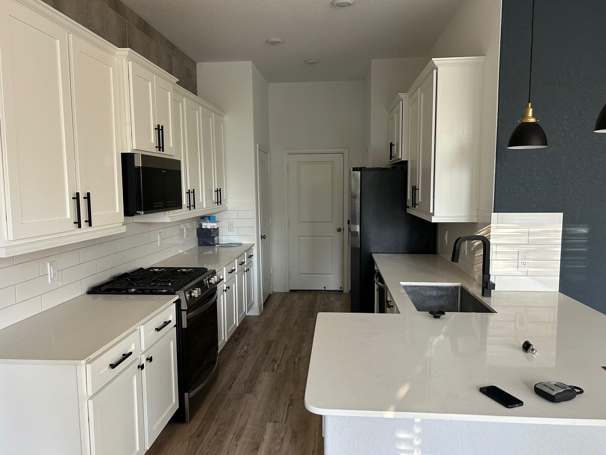 975 Lars Trek Trail Conroe, TX 77304 - Photo 9 of 36 a kitchen with granite countertop a sink a stove and refrigerator