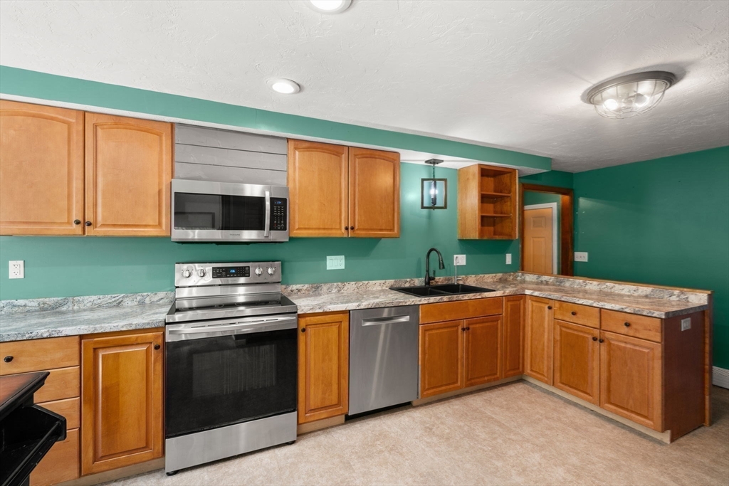 29 Chipper Hill Road Northbridge, MA 01534 - Photo 16 of 36 a kitchen with stainless steel appliances granite countertop a sink stove and microwave