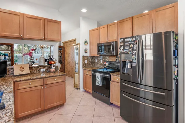 a kitchen with stainless steel appliances granite countertop a refrigerator sink and cabinets