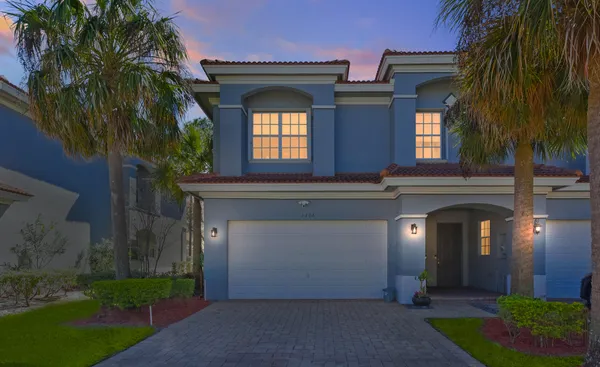 a front view of a house with plants and garden