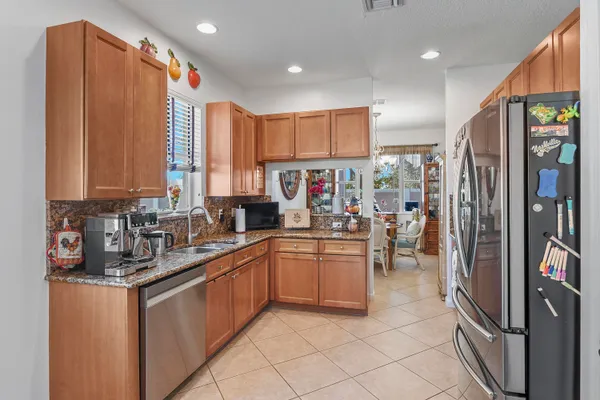 a kitchen with stainless steel appliances granite countertop a refrigerator and a sink