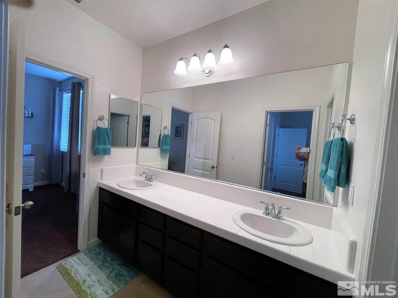 2165 Hope Valley Drive Reno, NV 89521 - Photo 13 of 22 a bathroom with double vanity sinks a vanity a lamp and a mirror