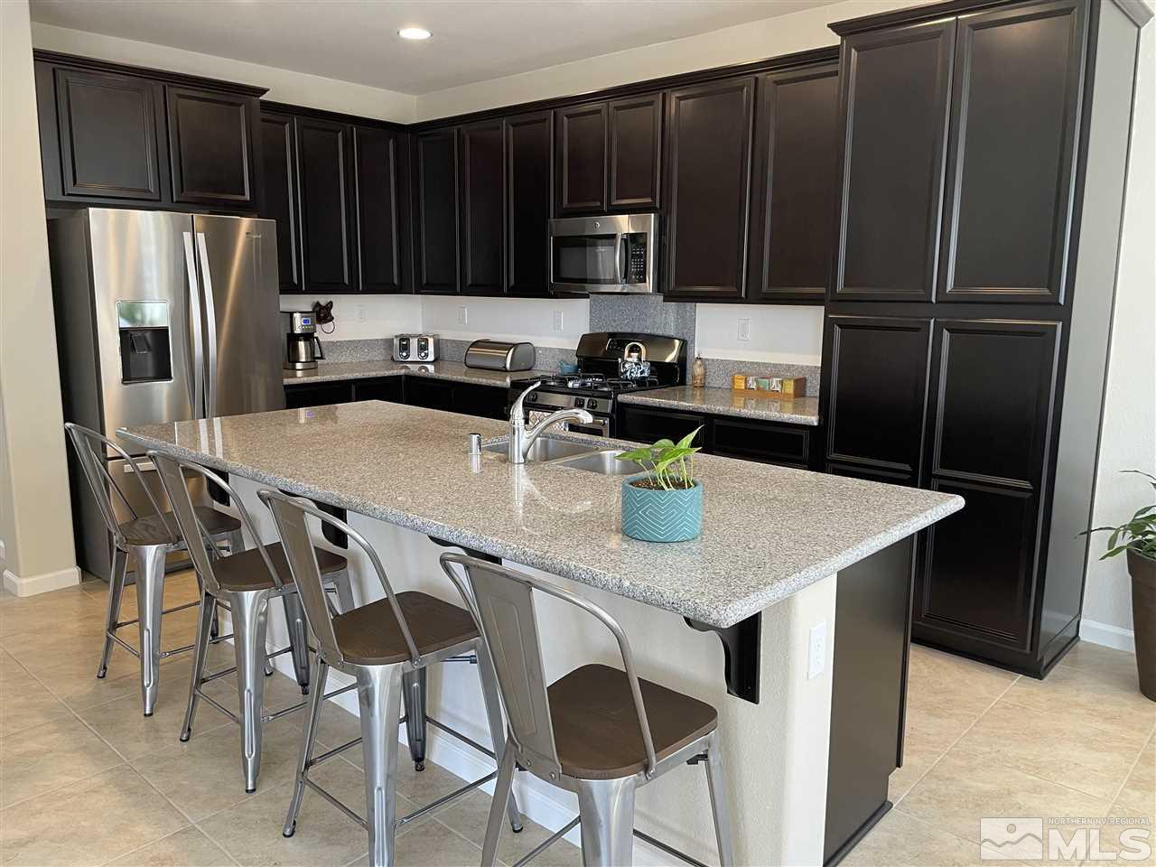 2165 Hope Valley Drive Reno, NV 89521 - Photo 4 of 22 a kitchen with stainless steel appliances granite countertop a table chairs refrigerator and sink