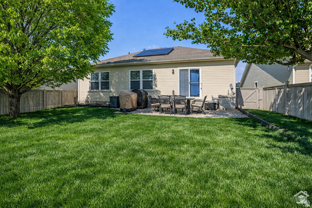 7092 Cherokee Street Eagle Mountain, UT 84005 - Photo 21 of 27 Expansive backyard featuring a lush lawn, mature trees, and a spacious paved patio