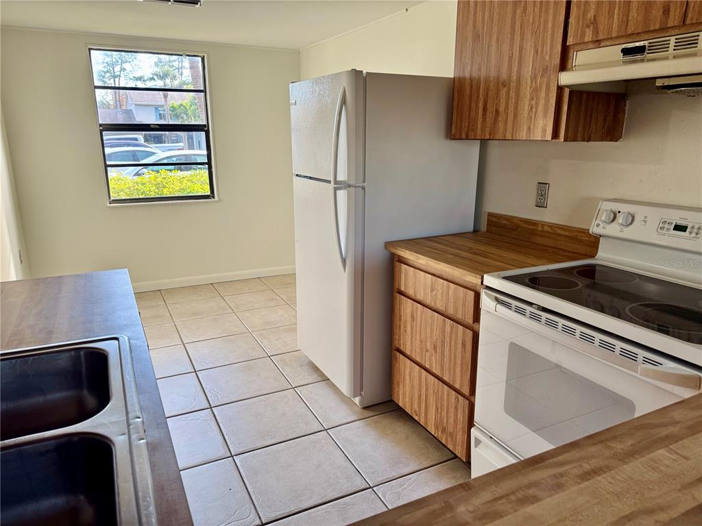 2131 Ridge Road South, Unit 105 Largo, FL 33778 - Photo 4 of 20 a kitchen with a stove a microwave and a refrigerator