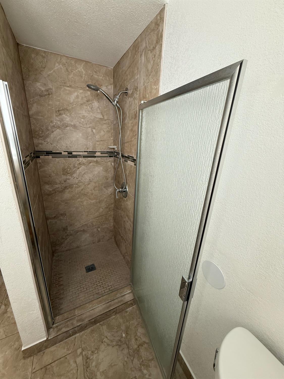 501 Rotan Avenue Madera, CA 93637 - Photo 9 of 23 a bathroom with a glass shower door