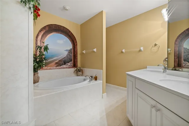 a bathroom with a tub sink and mirror