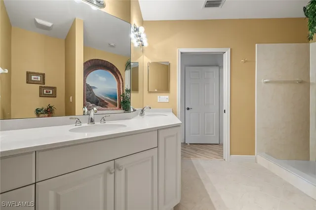 a en suite bathroom with a granite countertop sink and a mirror