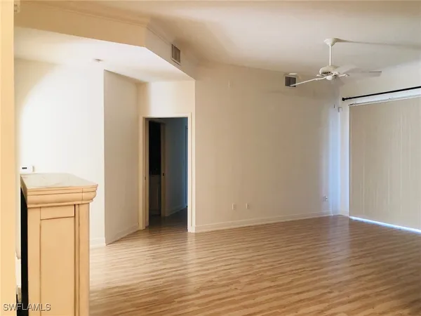 a view of an empty room with wooden floor