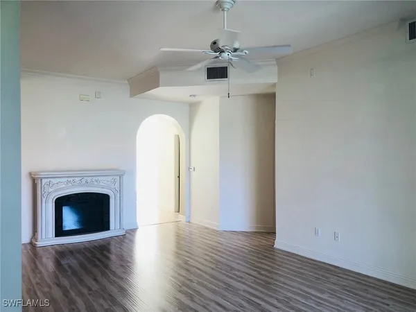 a view of empty room with wooden floor and fireplace