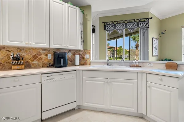 a kitchen with white cabinets and a sink