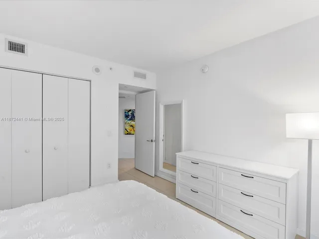 a bedroom with a bad and cabinet