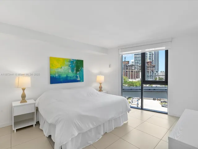 a bedroom with a bed and a lamp next to a window