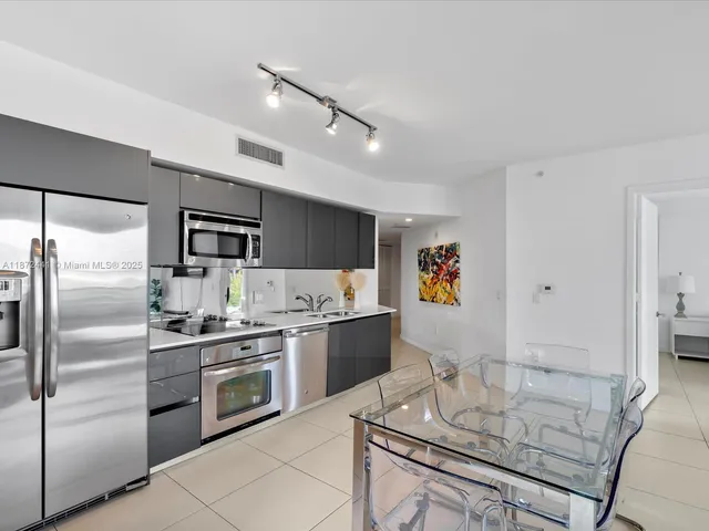 a kitchen with stainless steel appliances granite countertop a refrigerator sink stove and white cabinets