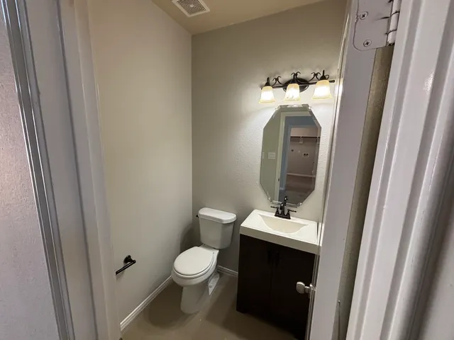 a bathroom with a toilet sink and mirror
