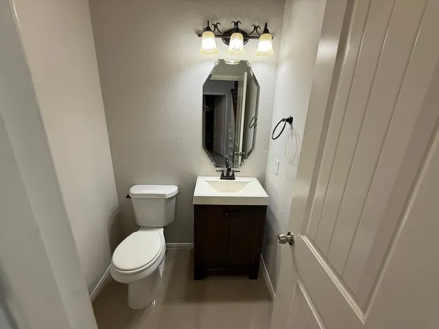 a bathroom with a toilet sink and mirror